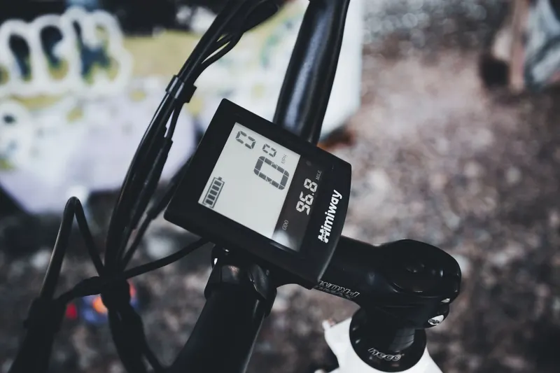 Detailed close-up of a bicycle handlebar featuring a digital speedometer display, emphasizing modern cycling technology