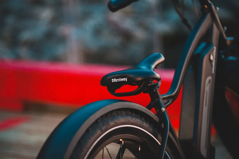 Detailed view of a black bicycle saddle and tire on a modern bike outdoors
