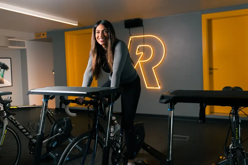 Smiling young woman enjoying a workout on a stationary bike in a Bahrain gym