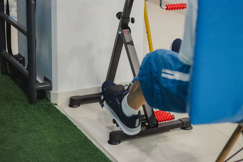 Close-up of a man working out on a stationary bike indoors, focusing on fitness and health